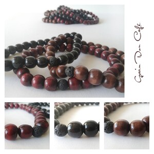 Peut inclure: Gros plan sur plusieurs bracelets de perles en bois dans les tons rouge foncé, marron et noir. Certains bracelets comprennent des perles de lave noires poreuses. Les bracelets sont présentés sur une surface blanche.