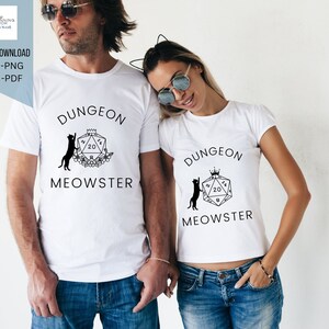 May include: Two white t-shirts with a black and white graphic design of a cat climbing a 20-sided die with the text "Dungeon Meowster".