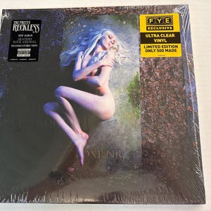May include: A sealed vinyl record album by The Pretty Reckless, titled "Death By Rock And Roll." The album cover features a nude person with long blonde hair. The record is a limited edition, ultra clear vinyl, with only 500 made.