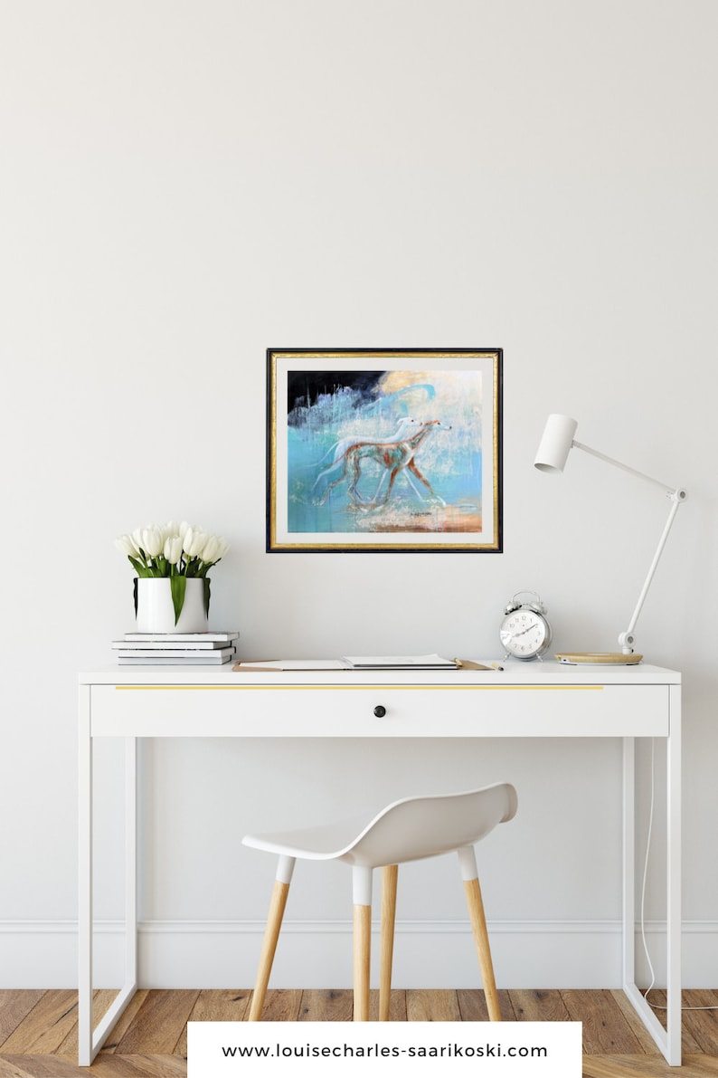May include: A framed painting of a white dog running through a blue and white abstract landscape. The painting is hanging on a white wall above a white desk with a white chair.