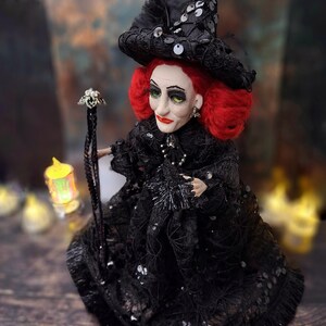 Top-down left side view of the handmade fancy witch art doll, showcasing her hand-painted face, whimsical witch outfit, and enchanting accessories.