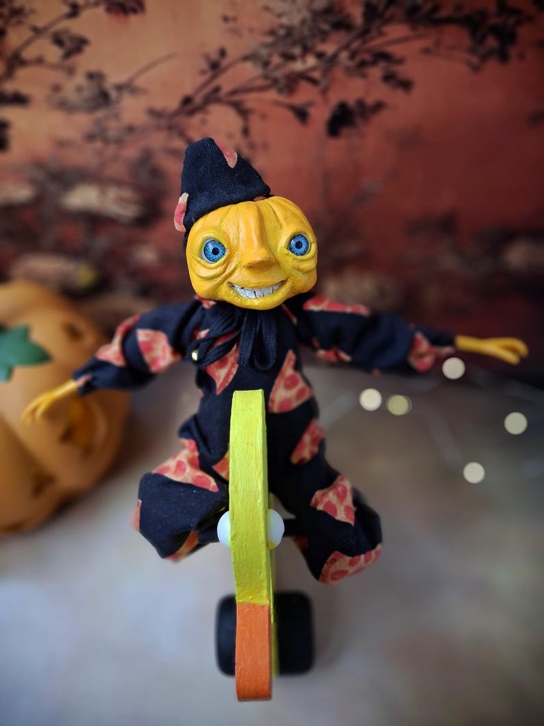 Top-down view of the handmade art doll standing upright, arms outstretched while playfully pushing a wooden wheeled duck toy, looking toward the camera, wearing a whimsical outfit.