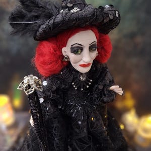 Close-up right angled side view of the handmade fancy witch art doll, showing her detailed hand-painted face, whimsical witch outfit, and enchanting accessories.