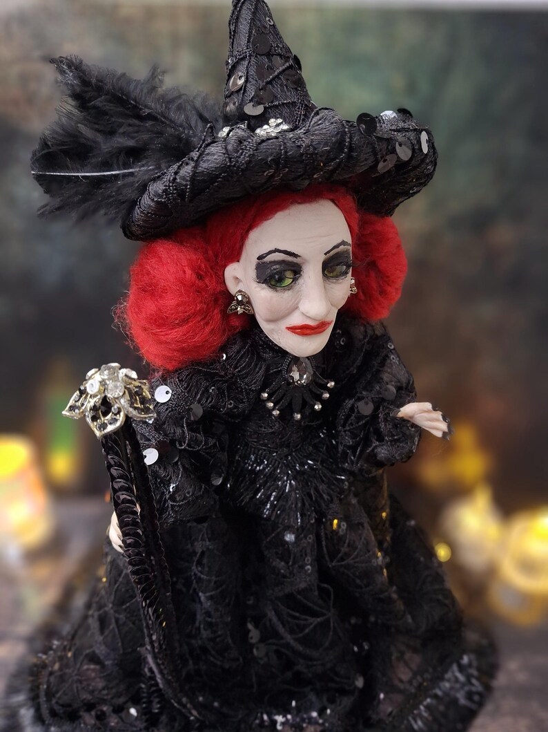 Close-up right angled side view of the handmade fancy witch art doll, showing her detailed hand-painted face, whimsical witch outfit, and enchanting accessories.
