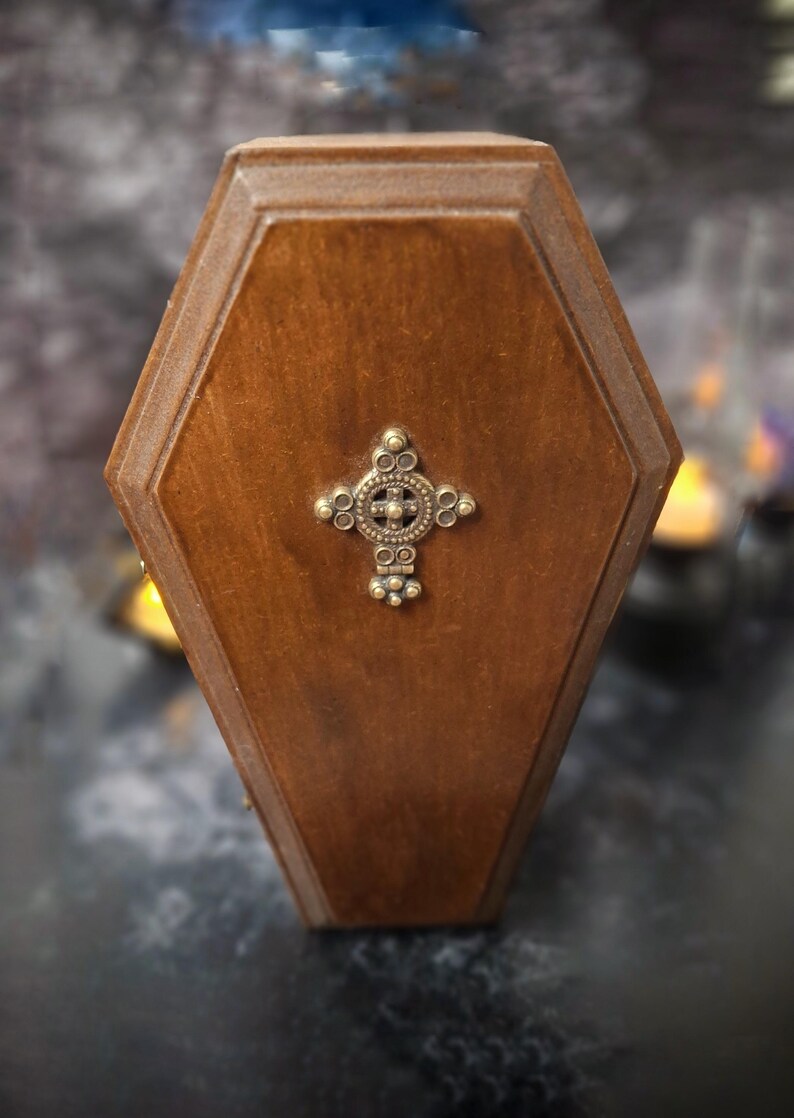 Front view of a closed wooden coffin designed with special fabrics and accessories inside, featuring a cross on top, a unique gothic Nosferatu vampire collectible perfect for spooky art displays, gothic decor, horror themed collections, and dark fantasy setups.