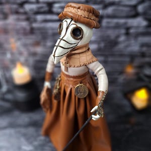 Handmade gothic plague doctor art doll viewed from upper left top angle, showing detailed handcrafted features and dark vintage gothic design.