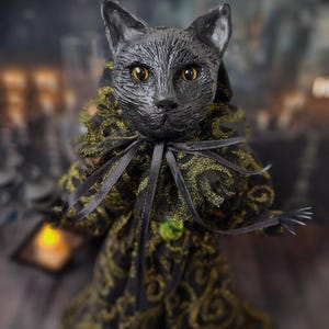 Close-up front view of a handmade black cat doll, highlighting detailed hand-painted facial features, whimsical gothic design, and sculpted details, a unique collectible perfect for black cat lovers, spooky home décor, Halloween displays, and gothic cat art collections.