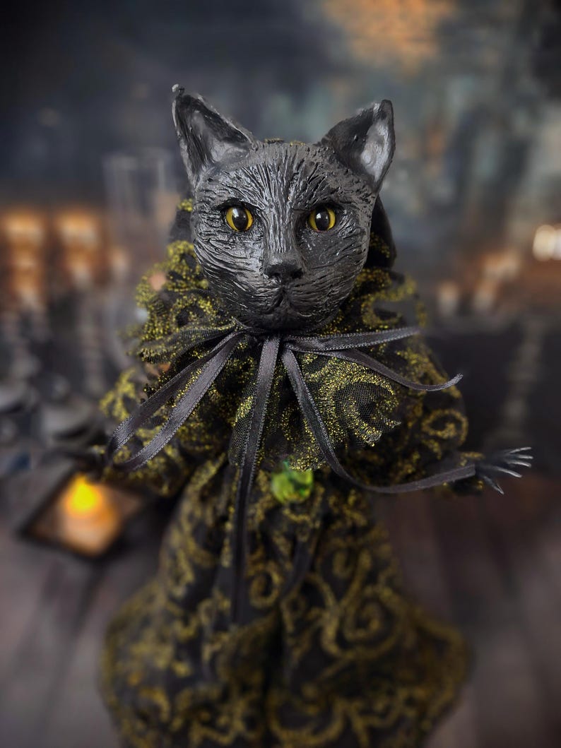 Close-up front view of a handmade black cat doll, highlighting detailed hand-painted facial features, whimsical gothic design, and sculpted details, a unique collectible perfect for black cat lovers, spooky home décor, Halloween displays, and gothic cat art collections.