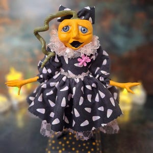 Front view of the handmade spooky Halloween pumpkin art doll, featuring her pumpkin-inspired outfit, detailed hand-painted face, and whimsical Halloween-themed accents.