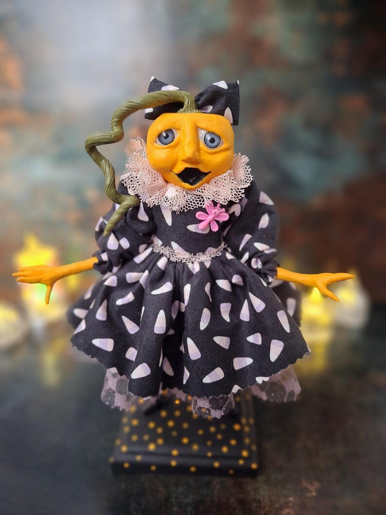 Front view of the handmade spooky Halloween pumpkin art doll, featuring her pumpkin-inspired outfit, detailed hand-painted face, and whimsical Halloween-themed accents.