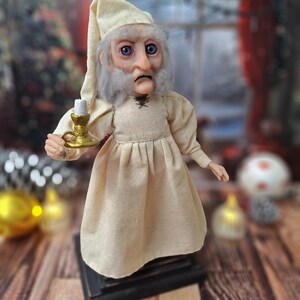 A right-side profile view of the Ebenezer Scrooge Art Doll, emphasizing the sculpted facial features, hand-painted details, and textured vintage-inspired outfit. The subtle festive accents and handcrafted charm are clearly visible from this angle.