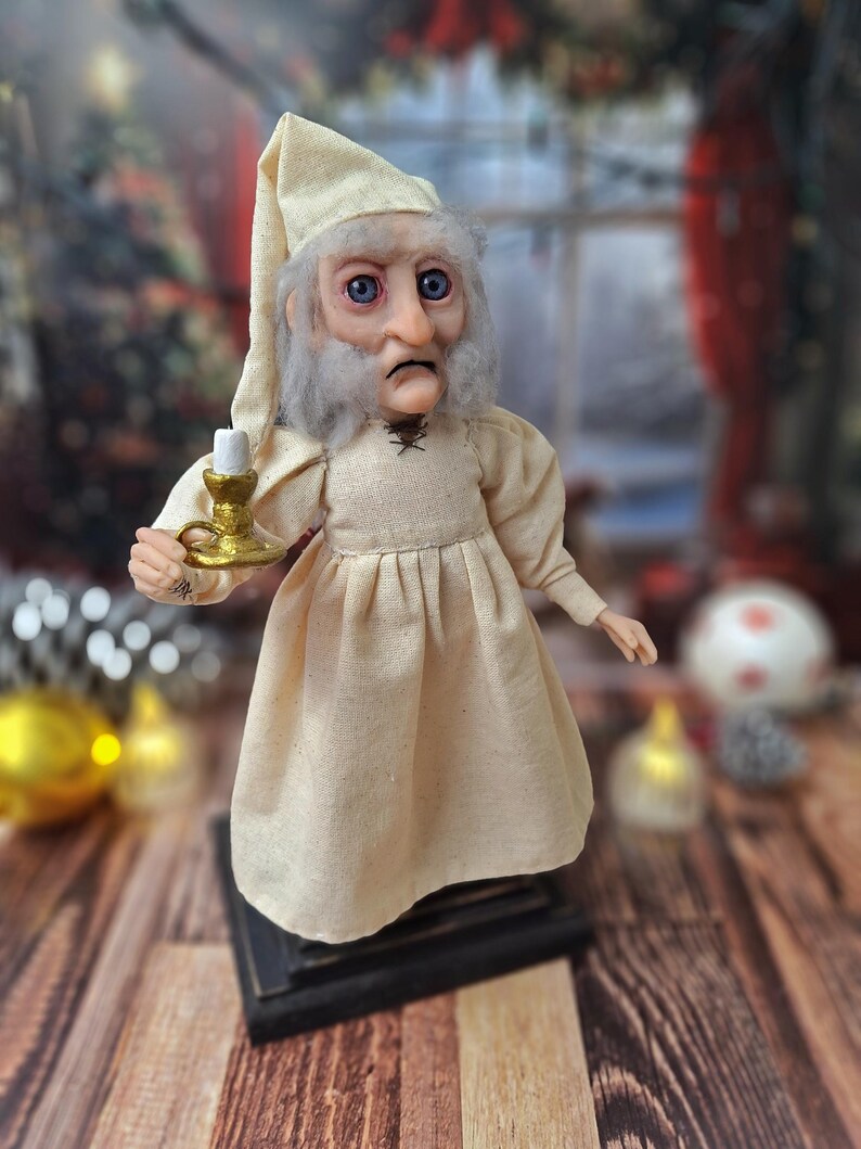 A right-side profile view of the Ebenezer Scrooge Art Doll, emphasizing the sculpted facial features, hand-painted details, and textured vintage-inspired outfit. The subtle festive accents and handcrafted charm are clearly visible from this angle.