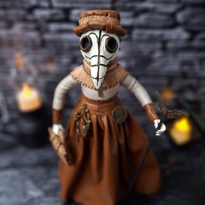 Handmade gothic plague doctor art doll viewed from straight top angle, showing detailed handcrafted features and dark vintage gothic design.