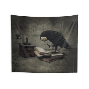May include: A black crow with a white face is perched on an open book. The crow is looking at the book with a curious expression. There is a wooden coffee grinder in the background.