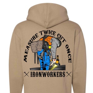 Puede incluir: Sudadera con capucha de color beige con un gráfico de un soldador con el texto "Measure Twice Cut Once" y "Ironworkers" en la espalda.