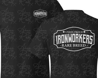 May include: Black t-shirt with a white graphic that says "Union Proud Ironworkers - Rare Breed" on a black background with a repeating pattern of "Above the Rest" in white.