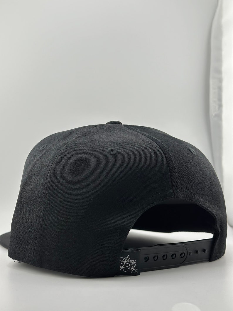 May include: Black baseball cap with an adjustable strap and a small white logo on the back.