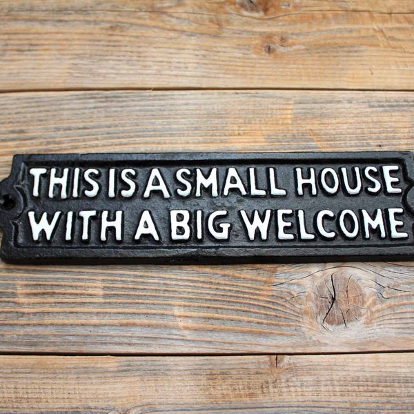Petite maison avec une grande plaque ou une grande plaque de bienvenue, plaque d'entrée en fonte