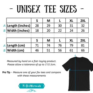 以下が含まれることがあります： ユニセックスTシャツのサイズ表が付いた黒いTシャツ。サイズ表には、Sから2XLまでのサイズのインチとセンチメートルの測定値が含まれています。「UNISEX TEE SIZES」と書かれています。「To Be Mermaids」のブランドロゴが下にあります。