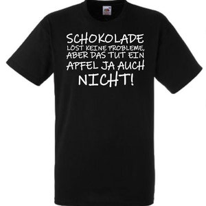 Könnte beinhalten: Schwarzes T-Shirt mit weißem Text, der "Schokolade löst keine Probleme, aber das tut ein Apfel ja auch nicht!" lautet.
