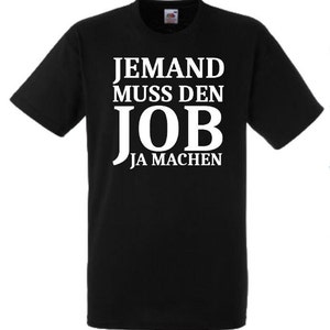 Könnte beinhalten: Schwarzes T-Shirt mit weißem Text, der "Jemand muss den Job ja machen" lautet.