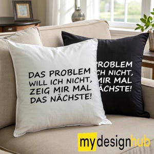 Könnte beinhalten: Zwei dekorative Kissen auf einem beigen Sofa. Eines ist weiß mit schwarzem Text: "DAS PROBLEM WILL ICH NICHT, ZEIG MIR MAL DAS NÄCHSTE!". Das andere ist schwarz mit weißem Text: "PROBLEM ICH NICHT, MIR MAL ÄCHSTE!".