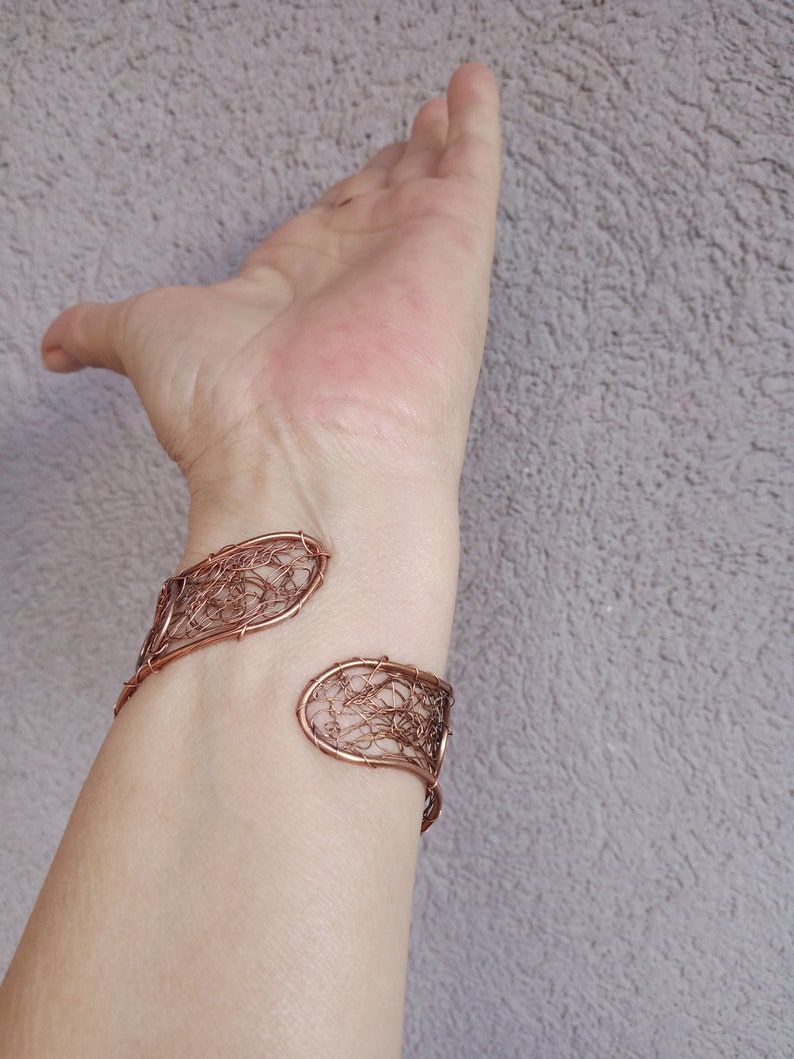 Pu&ograve; includere: Un braccialetto in filo di rame con un design delicato e intricato. Il braccialetto &egrave; aperto e regolabile per adattarsi a diverse dimensioni del polso.