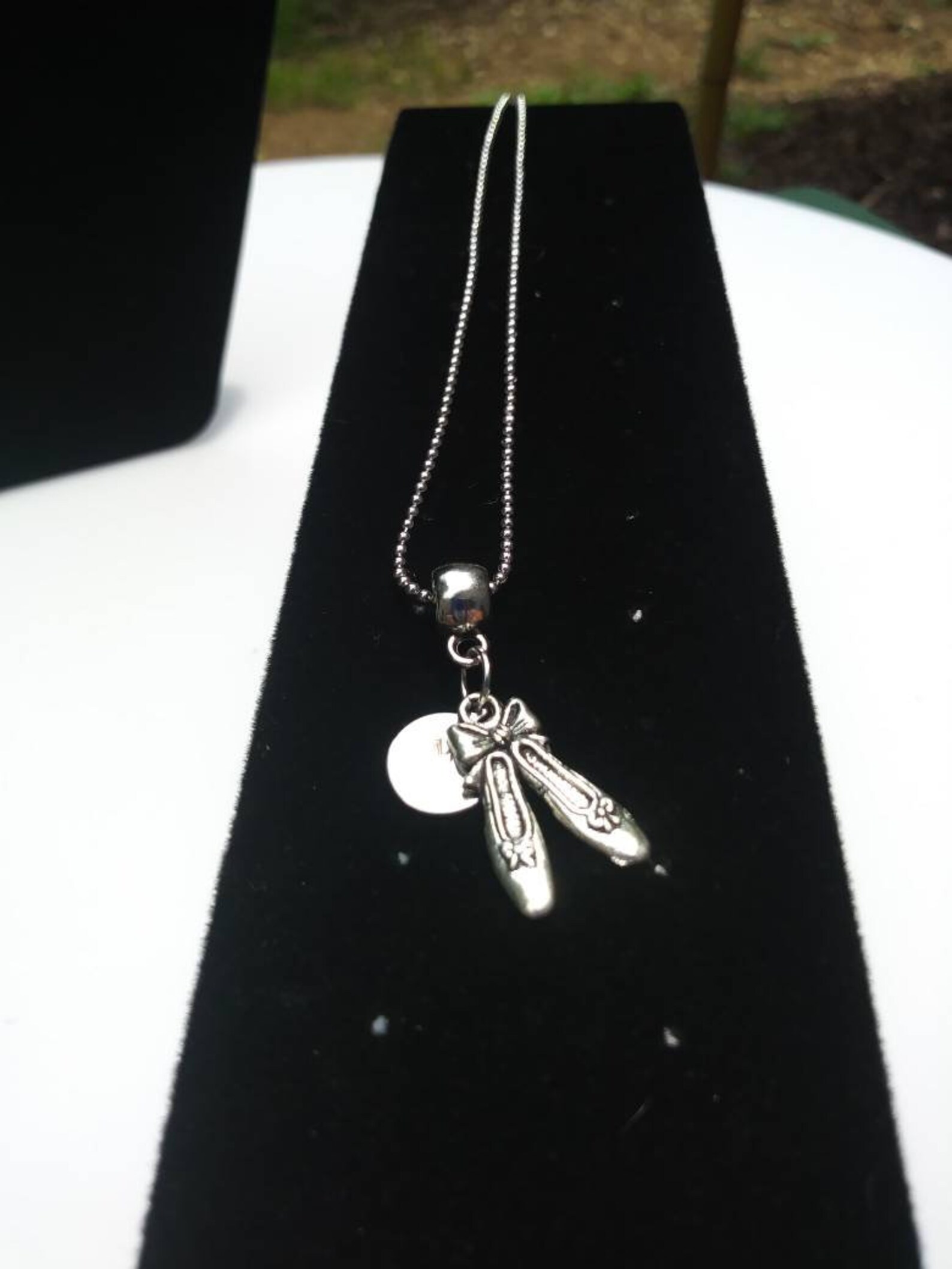 ballet shoes or ballet dancer hung on barrel bead charm holder and hung from silver plated/nickel free ballchain or black cordag