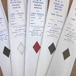 May include: Five spools of waxed thread for hand sewing. The spools are white with blue text and a small sample of the thread color on each spool. The colors are black, white, red, dark gray, and brown.