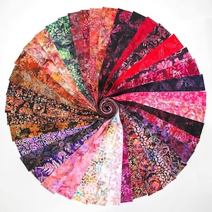 May include: A spiral of fabric strips in various colors and patterns. The fabrics include floral and abstract designs in shades of red, pink, purple, orange, and green. The strips are arranged in a circular fashion, with the ends rolled up in the center.