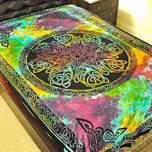 May include: A colorful tie-dye tapestry featuring a large Celtic knot design in the center. The tapestry is made of cotton and has a fringed edge.