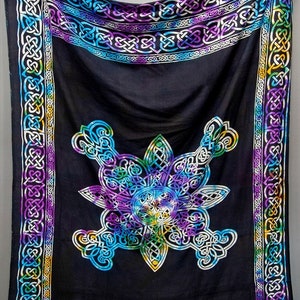 May include: A black tapestry with a colorful Celtic knot design. The tapestry features a large, intricate knot in the center, surrounded by a border of smaller knots. The colors of the knots are shades of blue, green, purple, and yellow.
