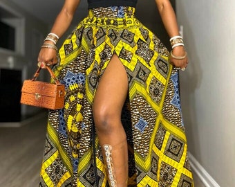 May include: A yellow and black maxi skirt with a high waist and a thigh-high slit. The skirt has a geometric pattern and is made of a woven fabric.