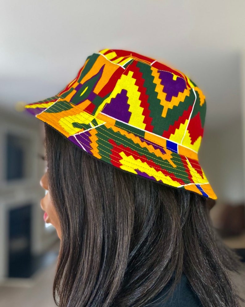 Op de afbeelding: Een gele, rode, groene en paarse bucket hat met een geometrisch patroon.