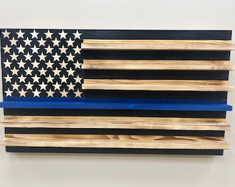 May include: Wooden wall shelf in the shape of an American flag with a blue stripe. The shelf has five shelves for displaying items.