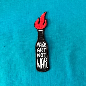 May include: Black and red embroidered patch featuring a Molotov cocktail design with the text "Make Art Not War".