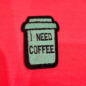 May include: Green embroidered patch of a coffee cup with the text "I NEED COFFEE" on a red background.