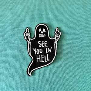 May include: Black and white embroidered iron-on patch of a ghost giving the middle finger with the text "See you in hell"
