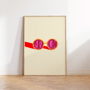 May include: A framed print with a yellow background featuring a pair of pink sunglasses with the word "PERSPECTIVE" written in red letters on the lenses.