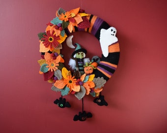 May include: A crocheted Halloween wreath with a black, orange, and purple striped base. The wreath is decorated with crocheted flowers, leaves, a ghost, a witch, and bats.