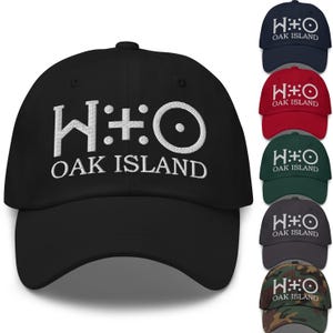以下が含まれることがあります： 白の刺繍テキストとグラフィックが入った黒い野球帽。「W:☩:O OAK ISLAND」と書かれています。ネイビー、赤、緑、グレー、迷彩の帽子も表示されています。
