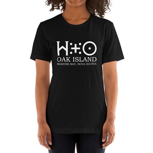 May include: Black t-shirt with a white graphic of the Oak Island symbol, "W:O", and the text "Oak Island, Mahone Bay, Nova Scotia."