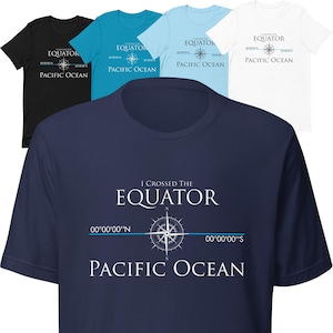 May include: A navy blue t-shirt with white text that reads "I crossed the equator 00°00'00"N 00°00'00"S Pacific Ocean". A compass rose is centered on the shirt with a blue line running through it.