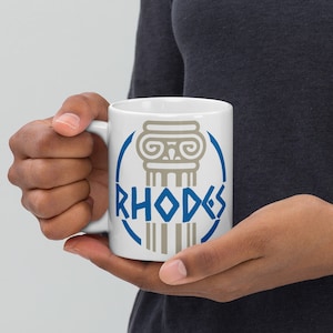 May include: White ceramic mug with a blue circle design featuring a gray column and the word "RHODES" in blue lettering.