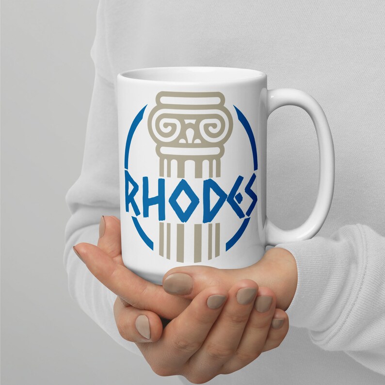 May include: White ceramic mug with a blue and gray design featuring a stylized column and the word "RHODES".
