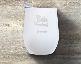 以下が含まれることがあります： 白いステンレス製のタンブラーに、「Bah Humbug Ebenezer」という白い文字が刻まれています。