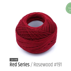 Puede incluir: Una madeja de hilo de bordar rojo, tamaño #40, etiquetada "Red Series / Rosewood #191".
