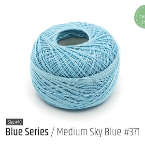 May include: A ball of light blue embroidery floss, size #40, labeled "Blue Series / Medium Sky Blue #371".