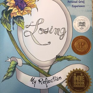 May include: A coloring book journal titled "Losing My Reflection" with a sunflower and a mirror illustration. The cover features award badges from the Midwest Book Award and the Indie Book Awards.