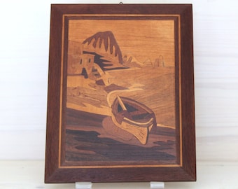 Wooden inlay painting depicting a seascape with a boat in the foreground